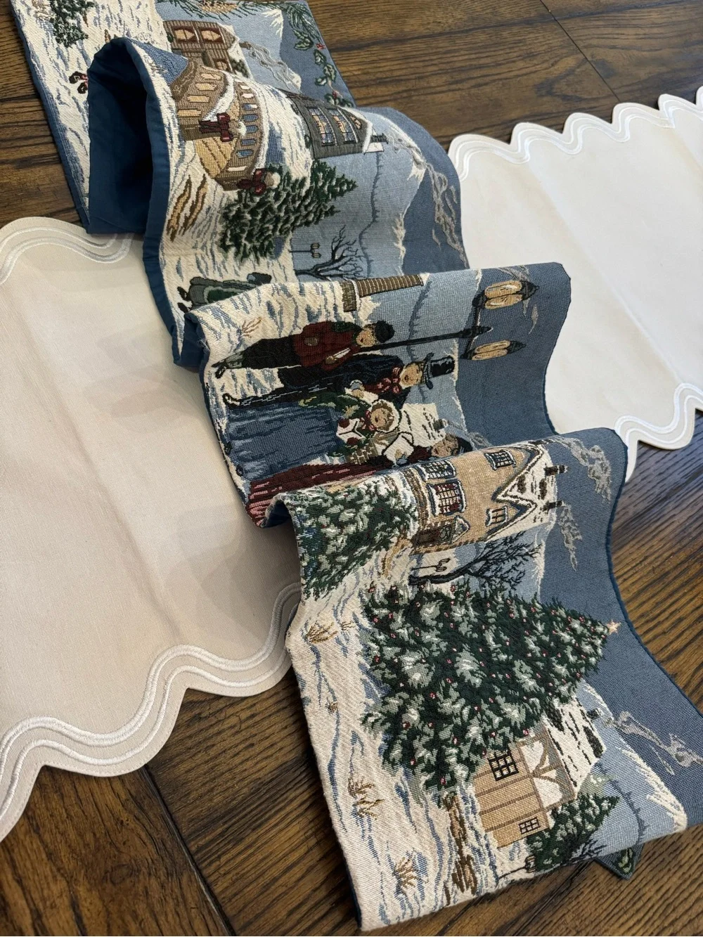 holiday-themed tapestry table runner featuring a snowy village 64”